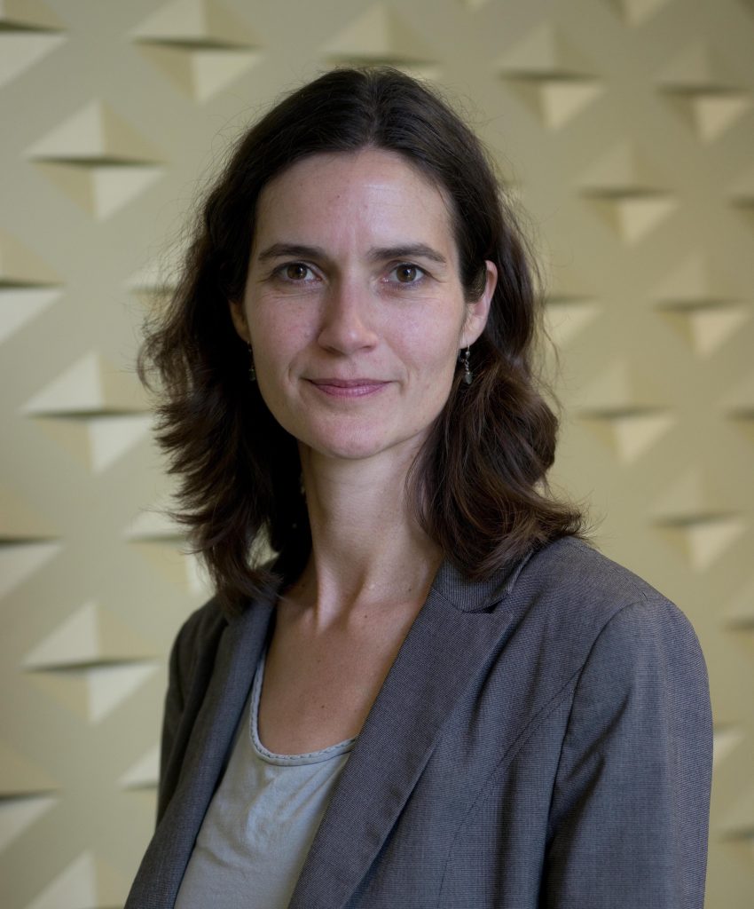 Das Bild zeigt Katja Triplett. Sie hat braune, gewellte Haare und lächelt freundlich in die Kamera.