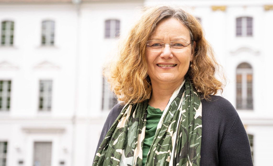 Das Foto zeigt Frau Prof. Dr. Stefanie Averbeck-Lietz vor dem Hauptgebäude der Universität Greifswald