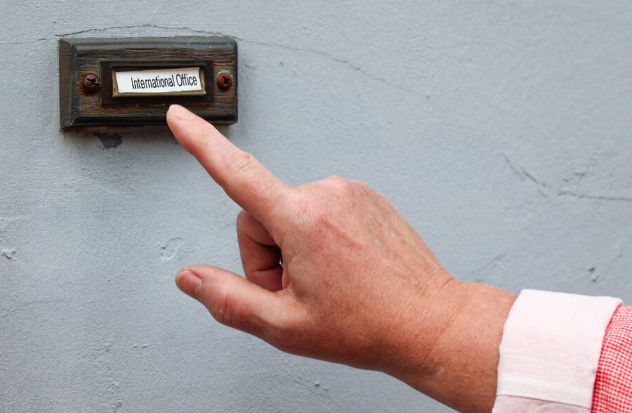 KLingel des International Office, eine Hand zeigt drauf