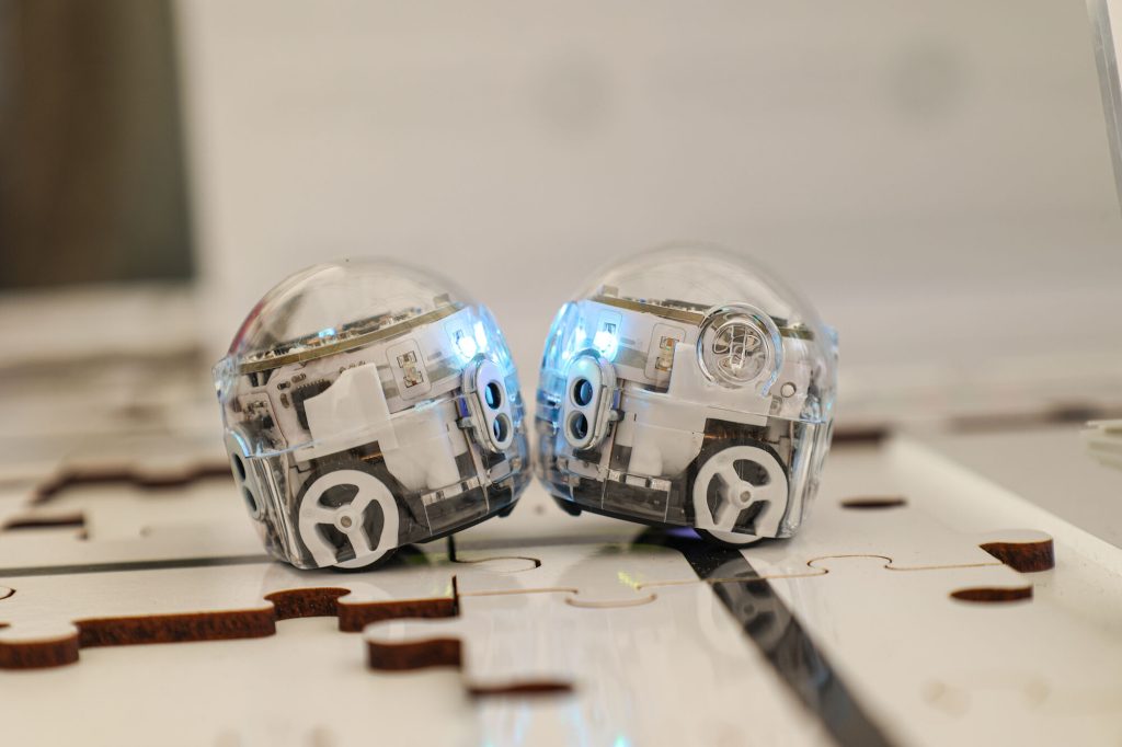 Auf dem Bild sind zwei kleine Roboter, die sogenannten Ozobots zu sehen.