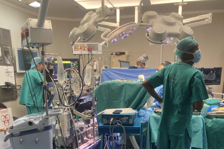 Das Foto zeigt einen Ausschnitt aus dem Krankenhaus-Alltag in Südafrika. Es ist ein Operationssaal zu sehen mit verschiedenen Geräten und Ärzten.