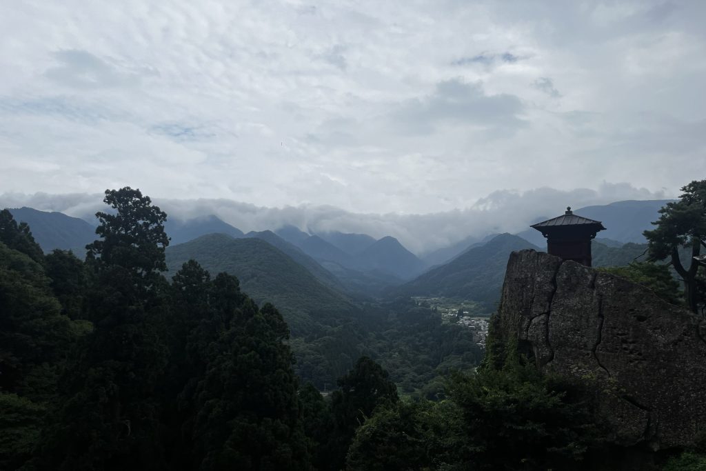 Das Bild zeigt den Ausblick von einer Tempelanalge auf die Weiten der Berge.