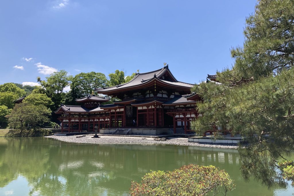 Das Foto zeigt die Byodo-in Tempelanlage. Es ist eine beeindruckendes Gebäude, das von Bäumen und einem kleinen See umgeben wird.