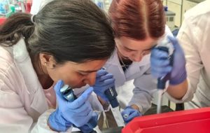 The photo shows Mariia working in the laboratory together with a fellow student.