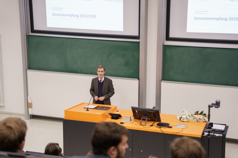 Der studentische Prorektor hält ein Grußwort zu Beginn des Semesterempfangs an der Uni Greifswald in einem Hörsaal