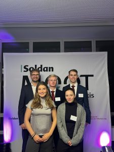 Fünf Teilnehmende des Wettbewerbs stehen zusammen für ein Foto vor einem Roll-Up