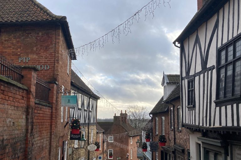 Das Bild zeigt eine Straße der englischen Stadt Lincoln, in der Lichterketten zwischen den Häusern aufgespannt wurden, um die Stadt festlich zu beleuchten.