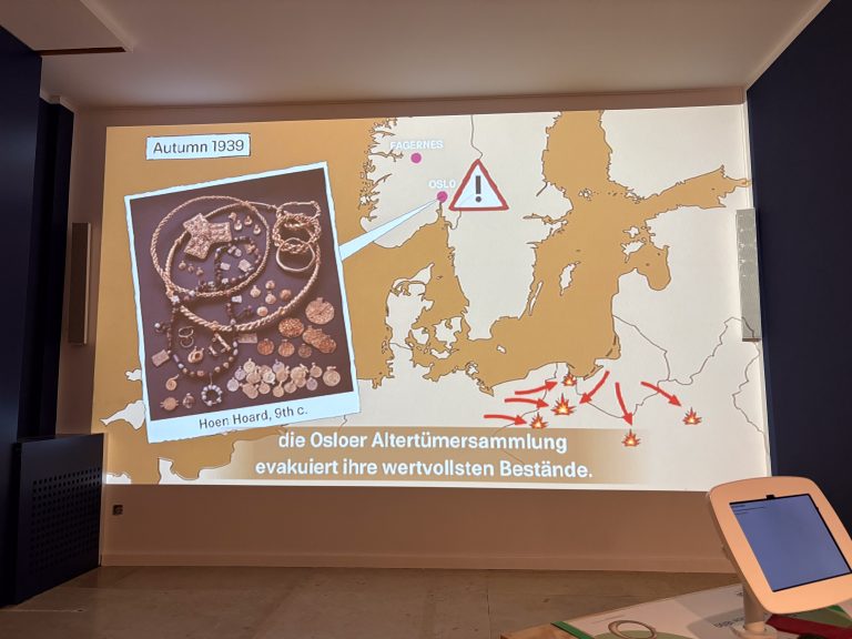 Ein Film läuft an einer Wand während einer Ausstellung in einem Museum