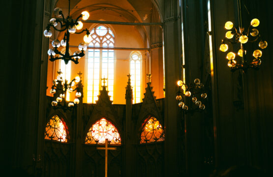 In eine Kirche leuchtet die Sonne, sodass es orange-gelb leuchtet.