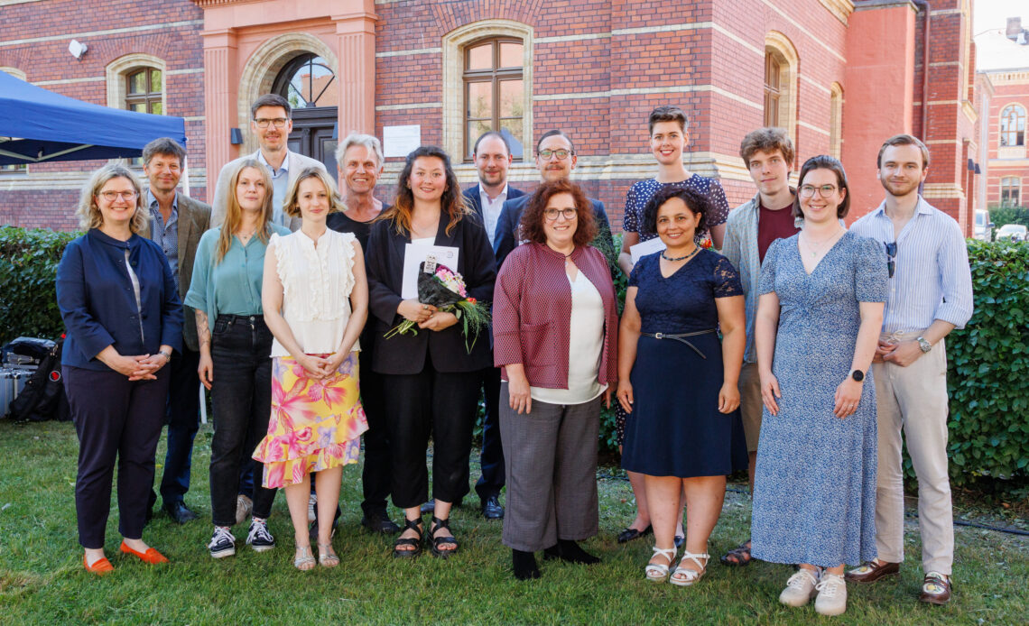 Viele gut gekleidete Menschen stehen für ein Gruppenbild nebeneinander