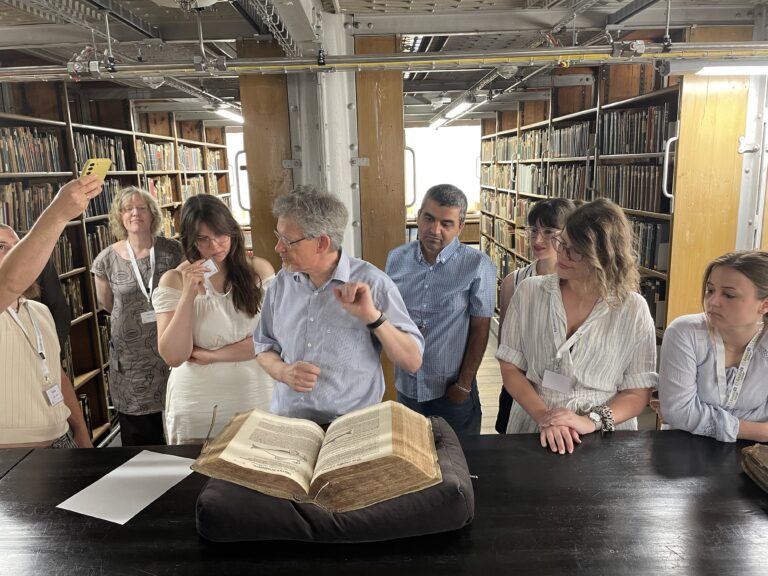 Eine Gruppe von Menschen ist in einer alten Bibliothek unterwegs