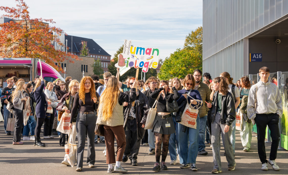 Mit Schildern sind Menschen zusammen unterwegs.